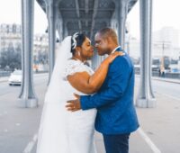 Elegant wedding couple embracing on a Paris bridge, symbolizing love and togetherness.