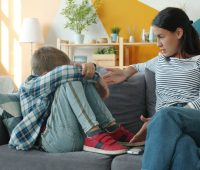 Mother comforts upset child on the sofa