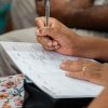 A woman writing in a calendar planner, highlighting organization and time management.