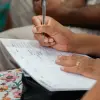 A woman writing in a calendar planner, highlighting organization and time management.