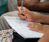 A woman writing in a calendar planner, highlighting organization and time management.
