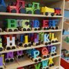 Colorful wooden alphabet letters on toy train wheels