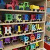 Colorful wooden alphabet letters on toy train wheels