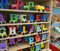 Colorful wooden alphabet letters on toy train wheels