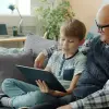 Grandfather and grandson looking at a tablet together