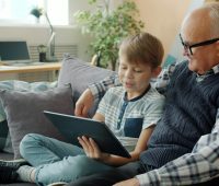 Grandfather and grandson looking at a tablet together