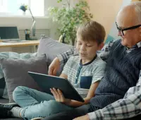Grandfather and grandson looking at a tablet together